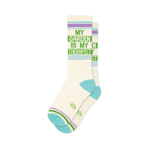 Pair of off-white crew socks with a green 'My Garden Is My Therapist' design and light purple and teal stripes.
