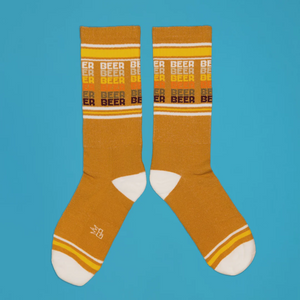 Lifestyle shot featuring feet wearing the mustard yellow 'Beer' socks.