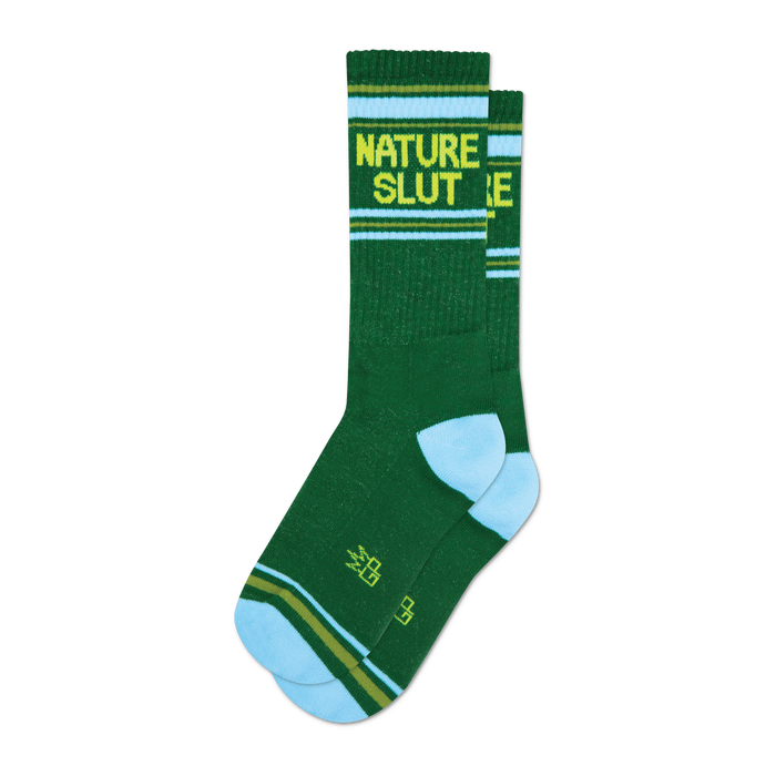 A pair of dark green crew socks with a light blue cuff and yellow 'NATURE SLUT' text. Features thin yellow and olive green stripes. }}