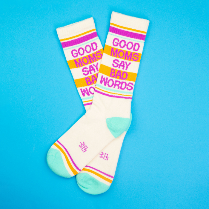 Flatlay product shot of 'Good Moms Say Bad Words' socks on a bright blue background.