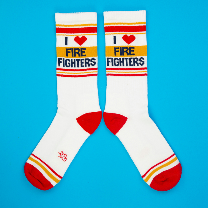 Flat lay product shot of a pair of 'I Heart Fire Fighters' socks against a bright blue background.