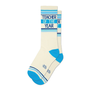 Pair of off-white crew socks with blue stripes and 'Teacher of the Year' text.