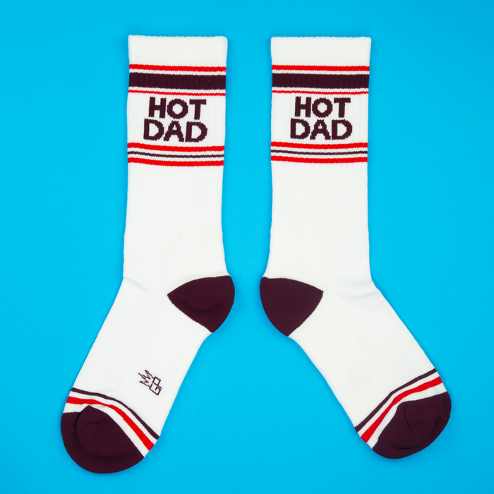 Flat lay product shot of 'Hot Dad' socks against a bright blue background.