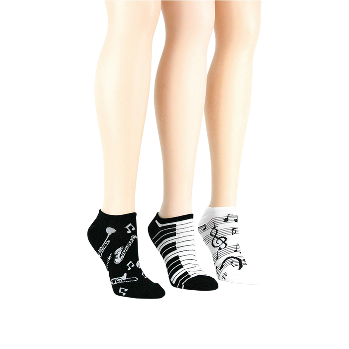 Lifestyle shot: three pairs of musical socks on mannequin legs.