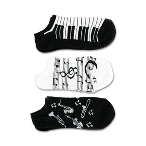 Three pairs of ankle socks; one black with musical instruments, one black and white piano keys, and one white with musical notes.