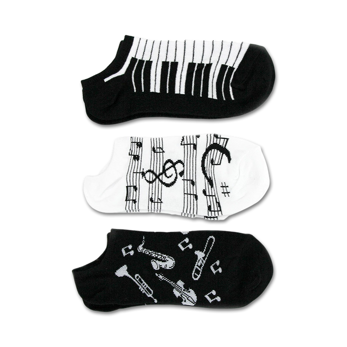 Three pairs of ankle socks; one black with musical instruments, one black and white piano keys, and one white with musical notes.