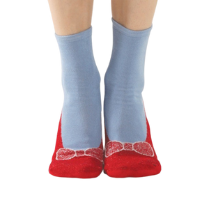 A lifestyle shot of a person wearing the red and light blue non-skid slipper socks.