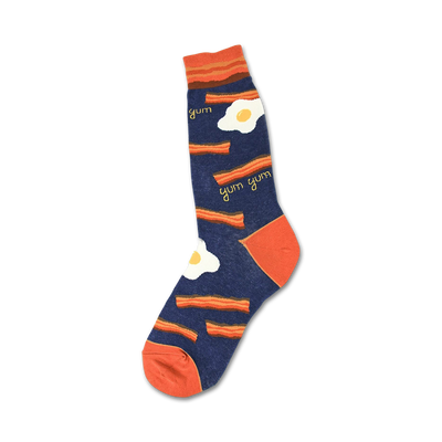 Crew socks in navy blue and orange, featuring a bacon and eggs design. The words 'yum' are scattered among the pattern.