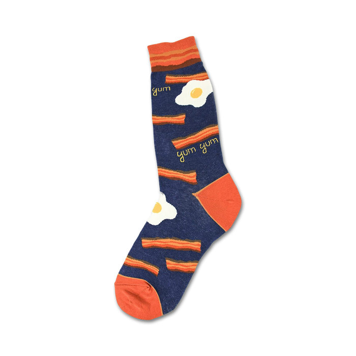Crew socks in navy blue and orange, featuring a bacon and eggs design. The words 'yum' are scattered among the pattern. }}