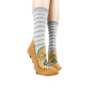 A pair of gray socks with brown toes and black soles with polka dots. The socks have the words 
