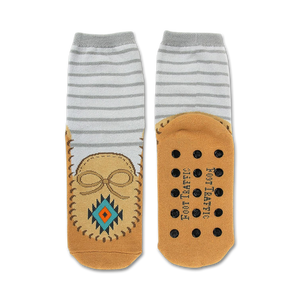 Pair of grey and tan slipper socks.  Moccasin design features on the tan bottom portion. Non-skid grips are visible on the soles.