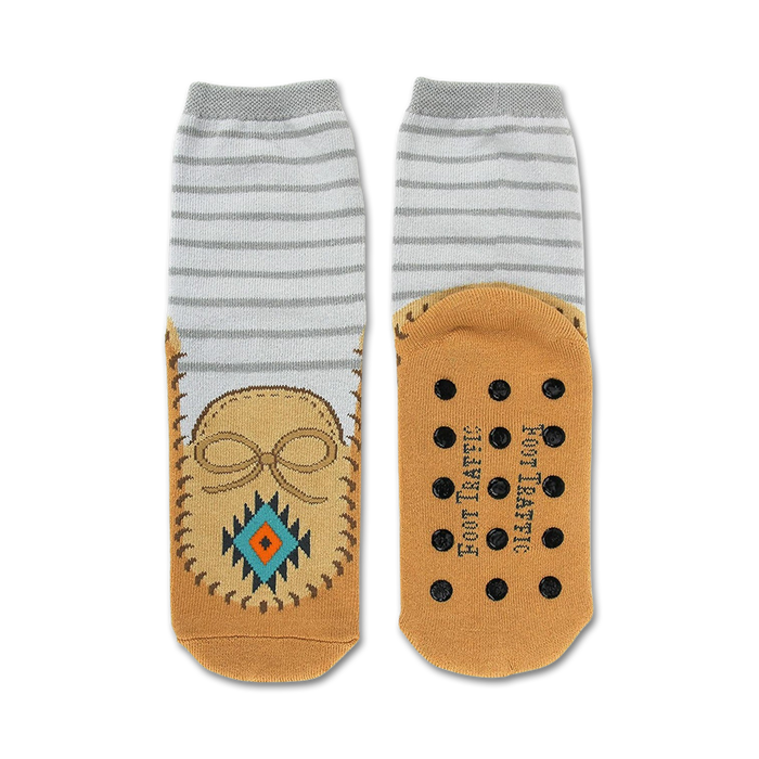 Pair of grey and tan slipper socks.  Moccasin design features on the tan bottom portion. Non-skid grips are visible on the soles.