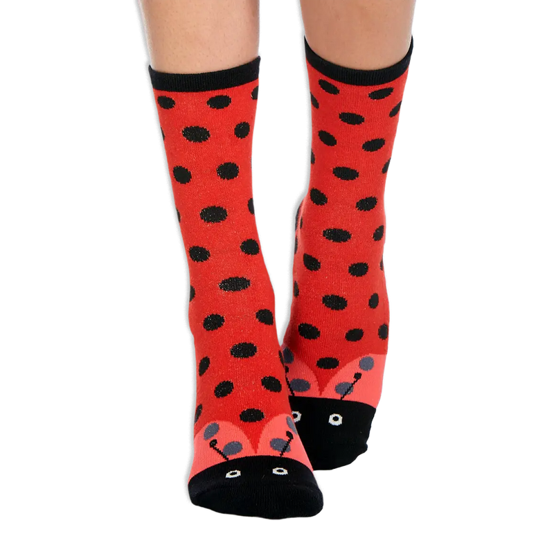 Red crew socks with black polka dots, a black cuff, and a ladybug face with eyes and antennas designed on the toe.