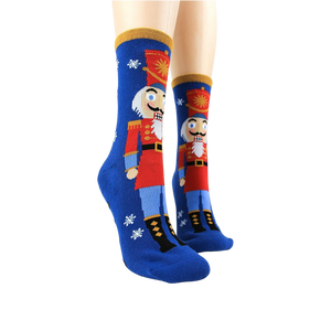 A pair of blue socks with a snowflake pattern and rubber treads on the bottom.