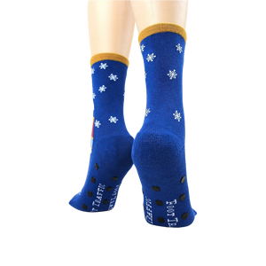 A pair of blue socks with a snowflake pattern and rubber treads on the bottom.