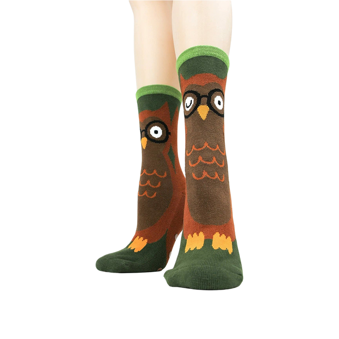 A pair of brown socks with green trim at the top and non-slip treads on the bottom.