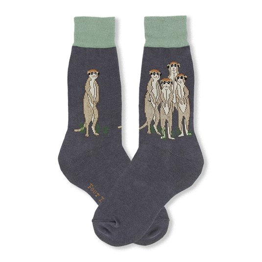 Dark grey crew socks with sage green cuffs featuring meerkats standing upright on small patches of green grass.