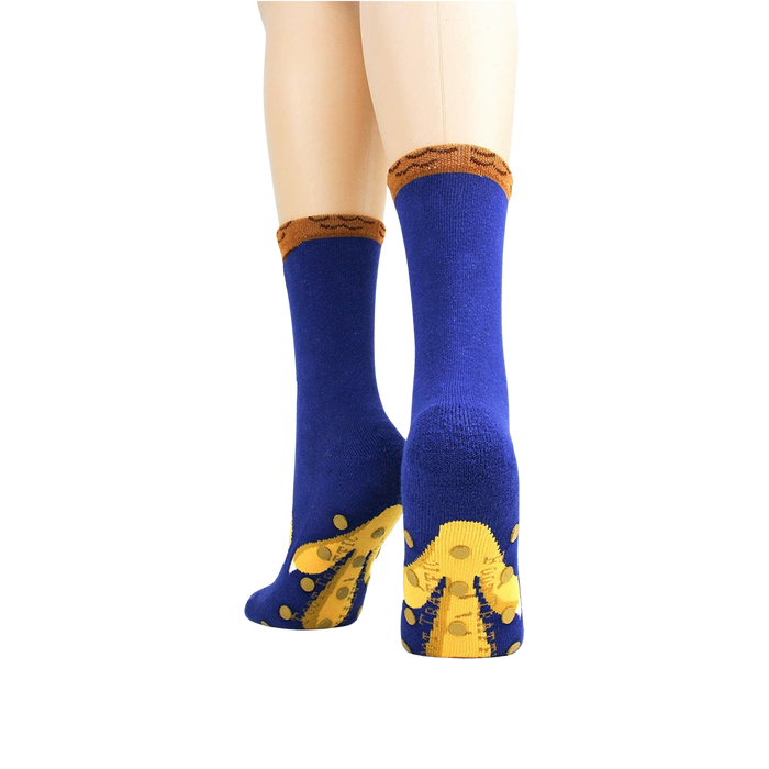 A pair of blue socks with yellow non-skid grippers on the bottom and a brown cuff.