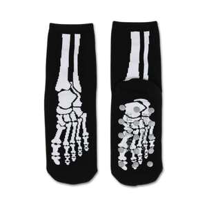 Pair of black non-skid slipper socks with a white skeleton bone design. Grippy dots on the bottom.