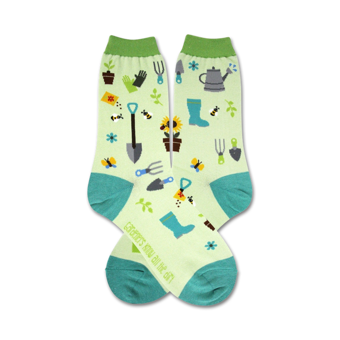 Pair of crew socks, light green with teal accents, featuring gardening tools, bees, sunflowers and other garden elements. }}
