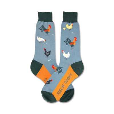 A pair of crew socks in blue, orange, and green. The socks are decorated with a pattern of roosters, hens, and chicks.