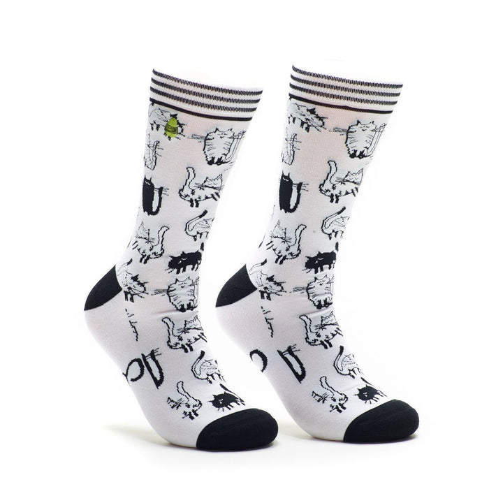 A pair of white crew socks covered in a repeating pattern of black and white cartoon cats. The socks have black heels and toes. }}