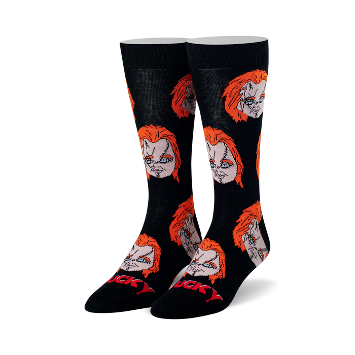 Pair of black crew socks with repeating pattern of Chucky's head featuring orange hair and stitched face. Red