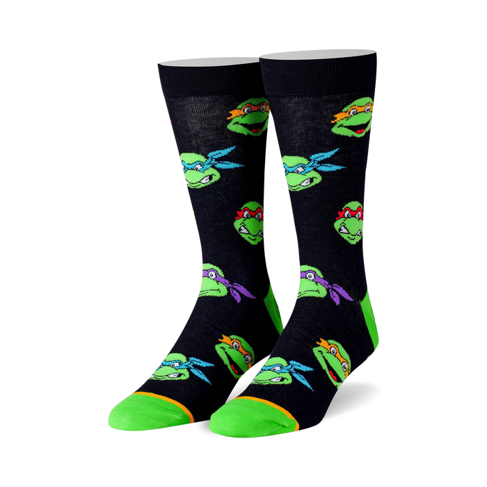 Crew socks in black with colorful Teenage Mutant Ninja Turtle head graphics. Lime green accents on the toes and heels. }}