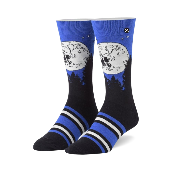 Pair of crew socks showcasing ET and Elliot silhouetted against a full moon on a dark blue background. Blue, black, and white stripes near the cuff. }}