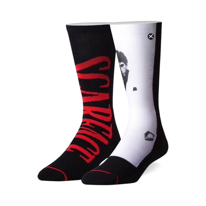 Pair of black and white crew socks. One sock features 'Scarface' in red, the other shows a black and white portrait of Al Pacino as Tony Montana.