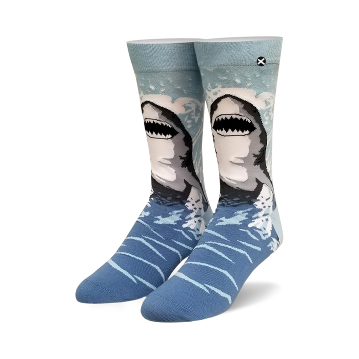 Pair of crew socks, blue and gray, with a great white shark design emerging from the water. }}