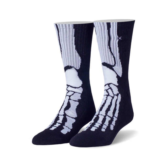 Pair of navy blue crew socks featuring a white skeleton foot and leg bone design. A small cross is subtly stitched on the upper part of the sock. }}