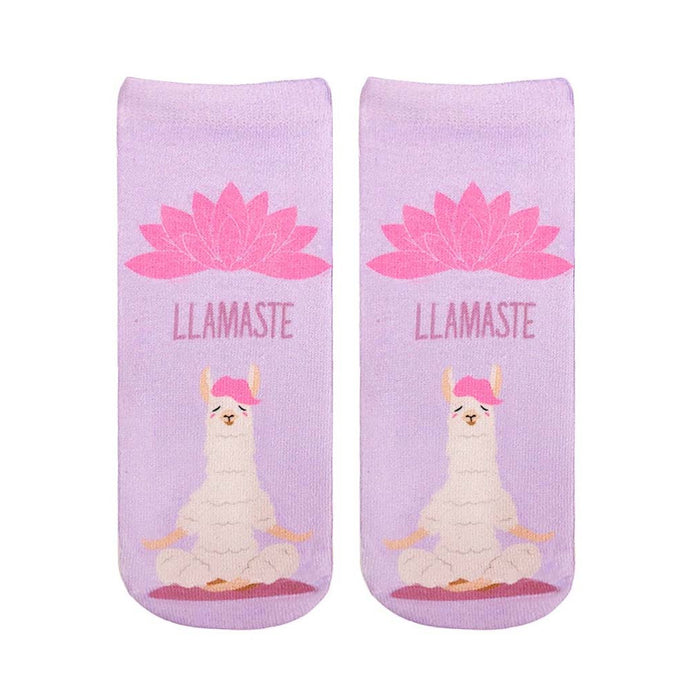 A pair of lavender ankle socks with a meditating llama and pink lotus flower. The socks feature the text