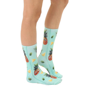 Lifestyle shot: A person's legs wearing the Googly Pineapple socks, showcasing how they look when worn.