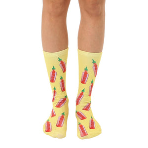 Crew socks in yellow with a repeating pattern of red and green hot sauce bottles. Fun and quirky design.