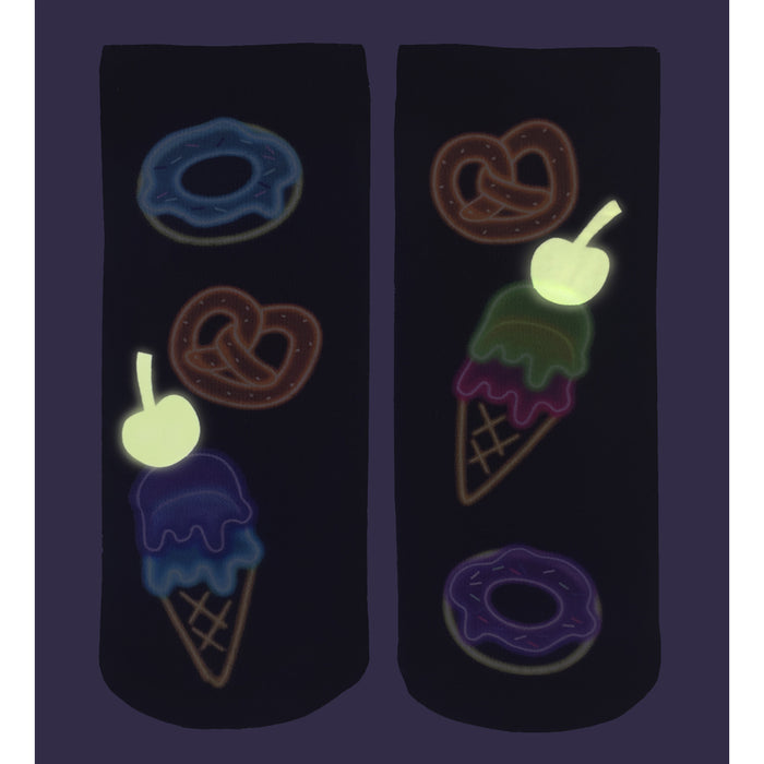A pair of black socks with a pattern of glow-in-the-dark food on them. The left sock has a blue donut, brown pretzel, and purple ice cream cone. The right sock has a purple donut, brown pretzel, and green ice cream cone.
