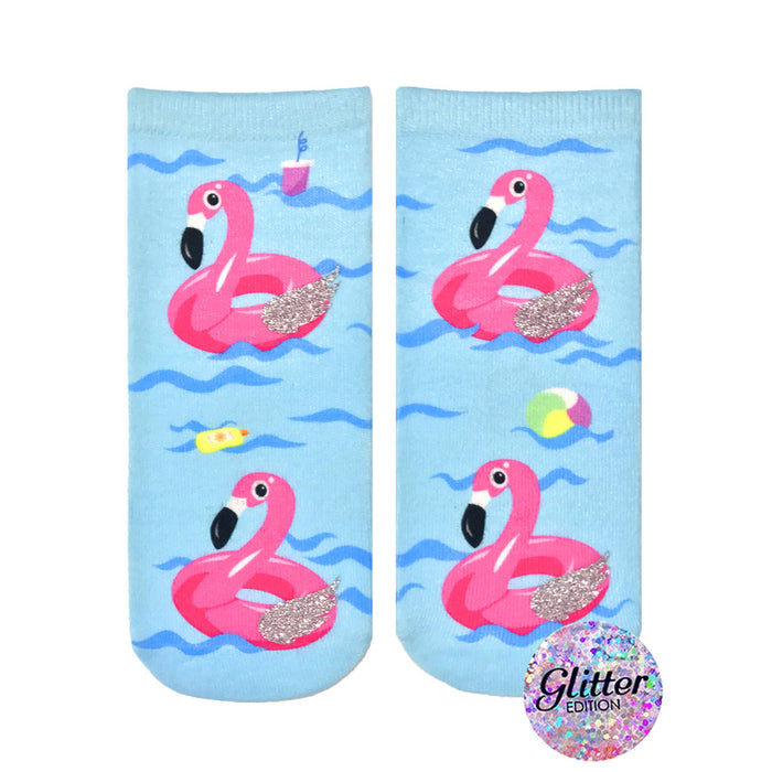 Crew socks featuring pink inflatable flamingos on a light blue wave background. Glitter accents add sparkle. Fun summer design. }}