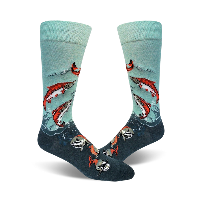A pair of teal and dark grey crew socks with a design of red sockeye salmon leaping from the water.  }}