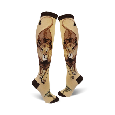 Pair of cream knee-high socks with a detailed brown lion design, including its mane and tail, and small tree accents at the bottom.