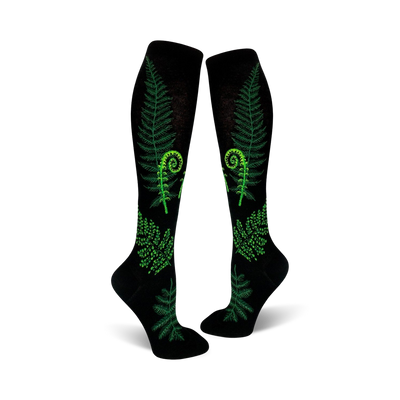 Pair of black knee-high socks featuring bright green ferns and fiddleheads. Botanical print on a black background.