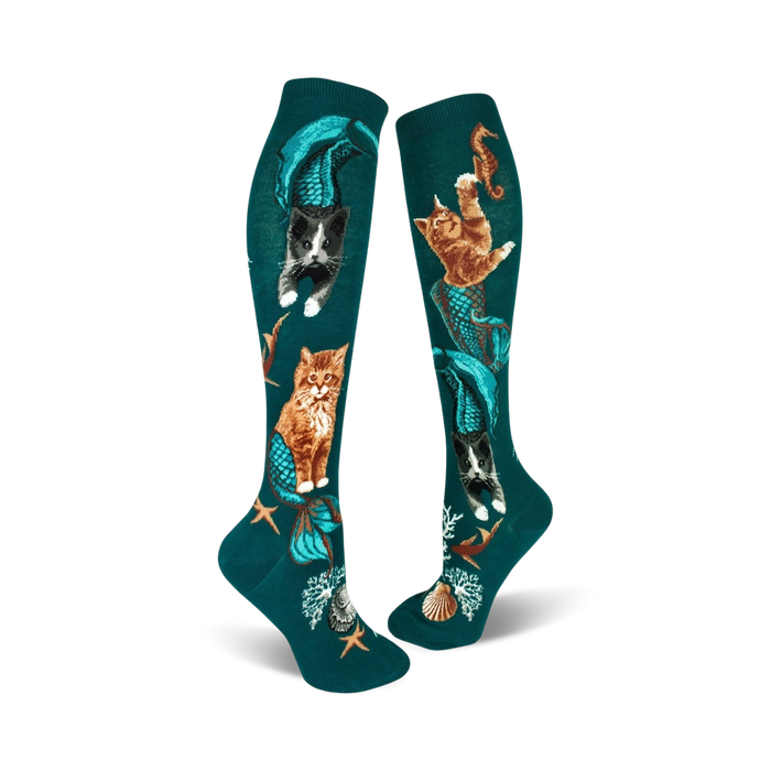 A pair of teal knee-high socks showcasing cats with mermaid tails.  Other designs include seahorses, starfish, and seashells. }}