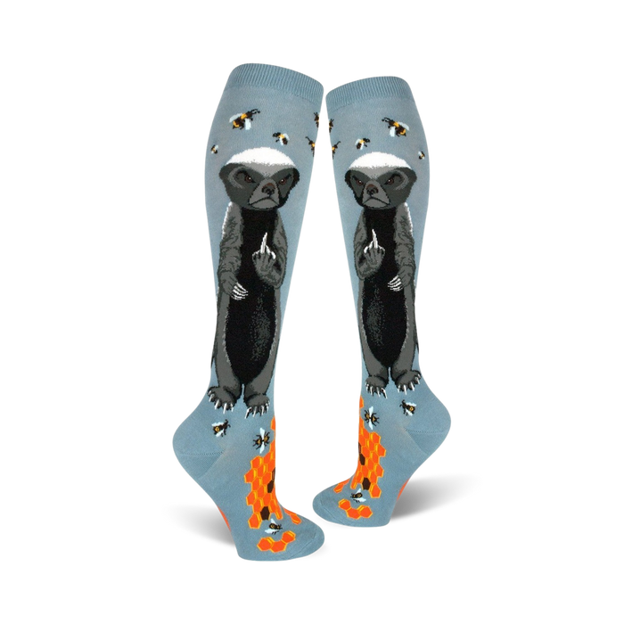 Pair of light blue knee-high socks with a honey badger giving the middle finger, bees, and honeycomb design. }}