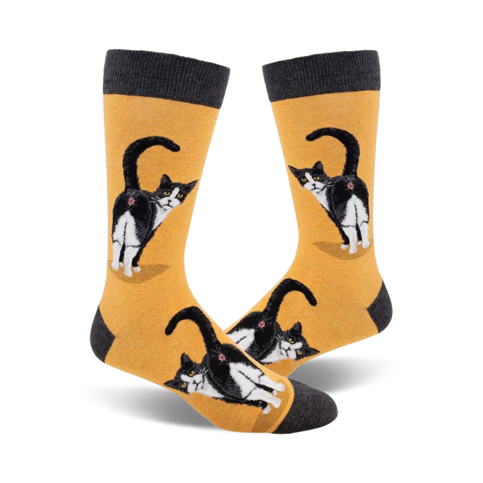 Pair of crew socks; mustard yellow and charcoal grey; featuring a tuxedo cat's rear end, repeated pattern.