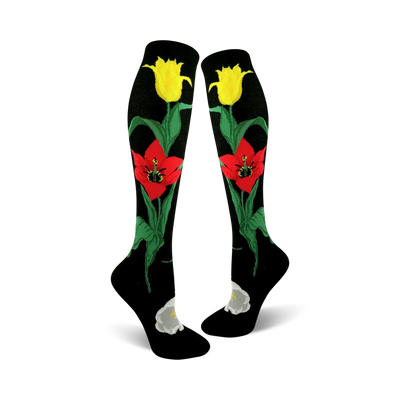 Pair of black knee-high socks with red and yellow tulips and green stems. A white flower is at the ankle.