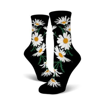 A pair of black crew socks featuring a whimsical pattern of white daisies with yellow centers and green stems.