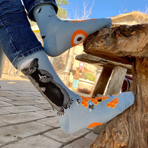 Lifestyle shot of Honey Badger socks being worn outdoors. Shows the socks on a person's feet in a different outdoor setting.