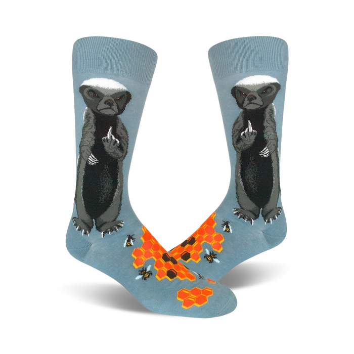 Pair of crew socks; light blue with a honey badger giving the middle finger, honeycomb, and bees illustrated.