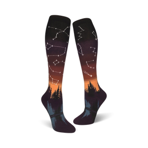 black womens knee high constellations socks with an all-over pattern of white, yellow stars and orange, yellow trees.   