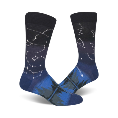 Pair of crew socks in navy blue and dark teal. Constellation design fades into a forest scene at the bottom.