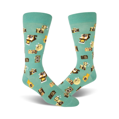 Pair of teal crew socks with a whimsical pattern of retro cameras and flashes in yellow and brown. Fun and quirky style.